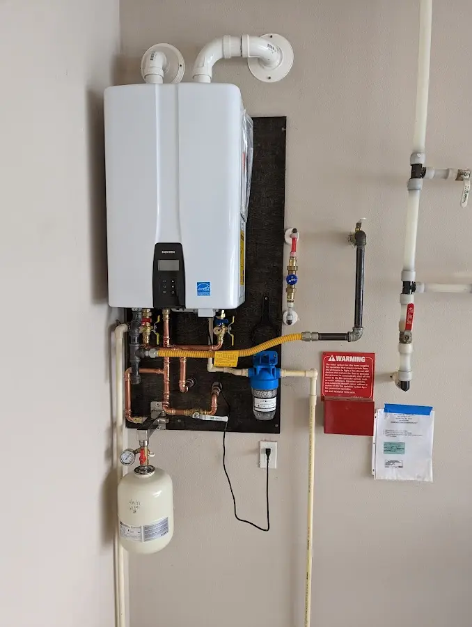 Professional plumber installing copper piping in a Pepperell home